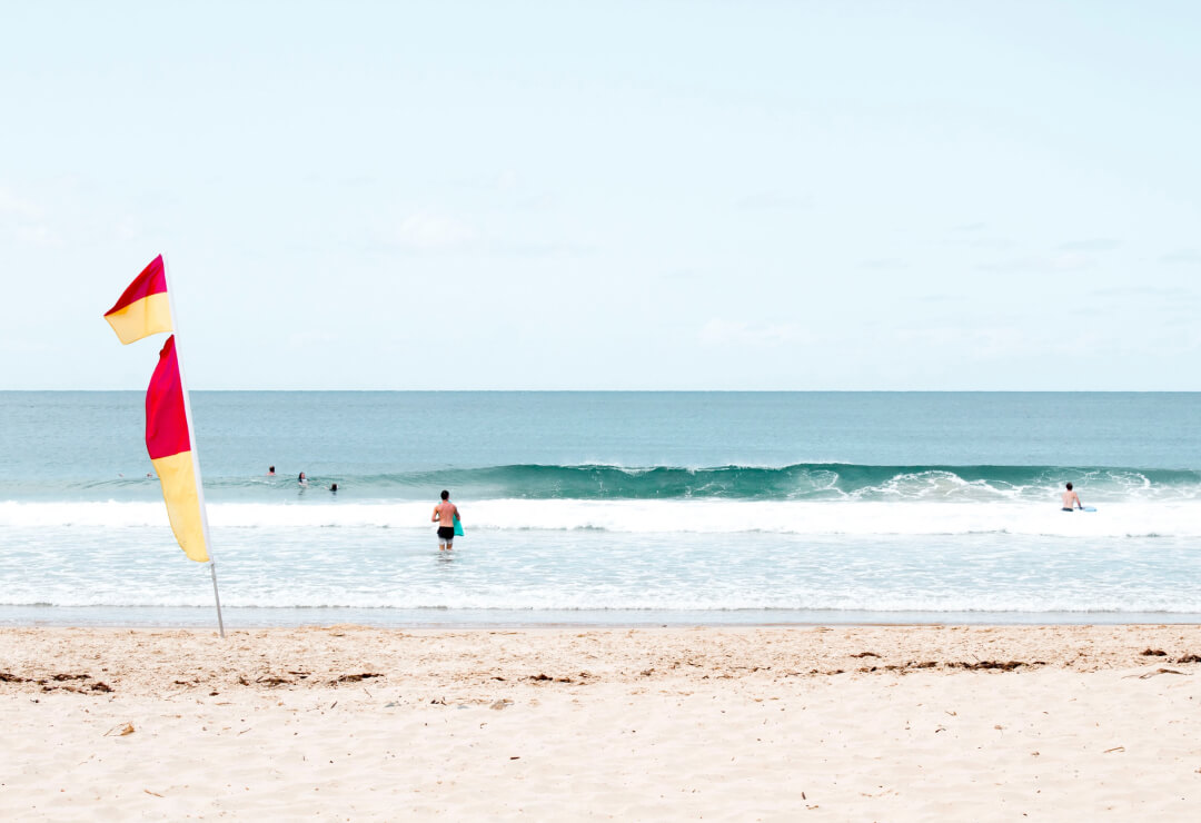 Beach with red and yellow flags